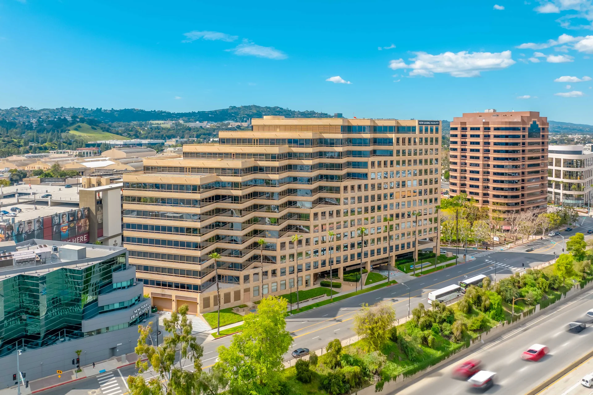 Exterior of a stepped tan office building beside palm-lined streets in Burbank, California.
