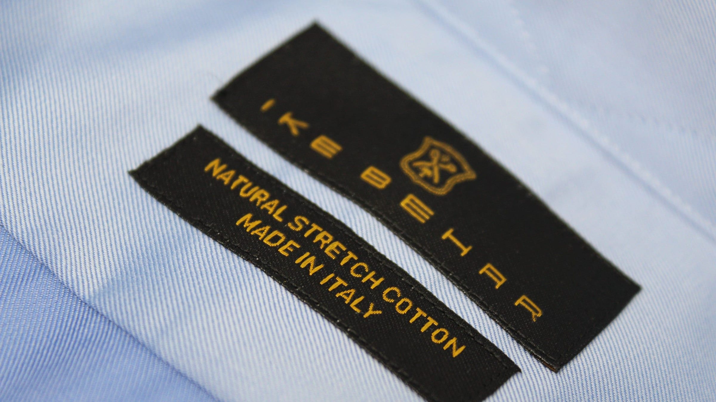 An Ike Behar crest label and a Natural stretch cotton, Made in Italy label on light blue twill.